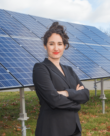 Jenny Rushlow standing in front of solar panels